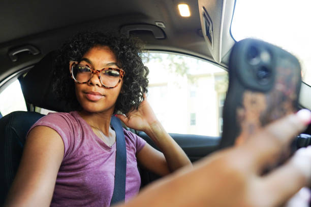 istock Young woman taking selfies while driving 1649081530