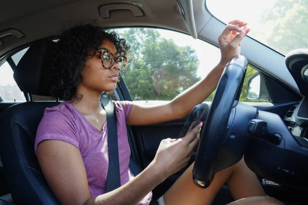 istock Young woman texting and driving 1649081533