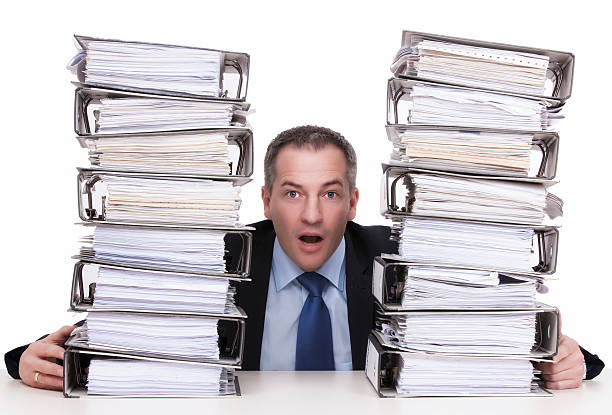 istock businessman between Stacks of ring binders 164908791