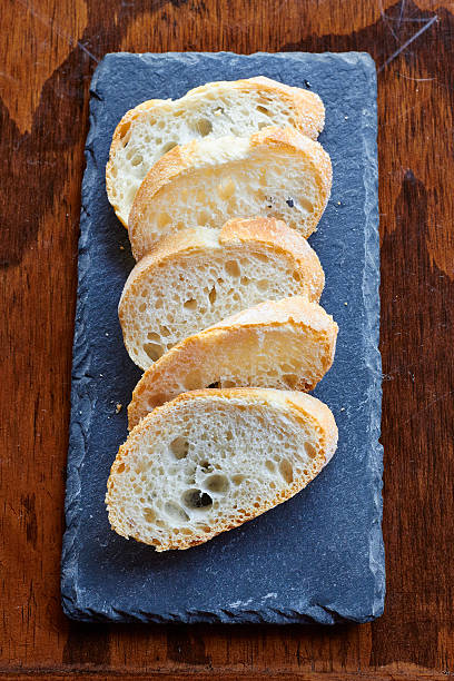 Sliced french bread on slate board stock photo