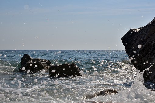 Sea waves crashing on rocks. Adriatic Sea shore on a sunny day.