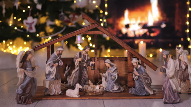 Jesus Christ Nativity scene in atmospheric lights near Christmas tree