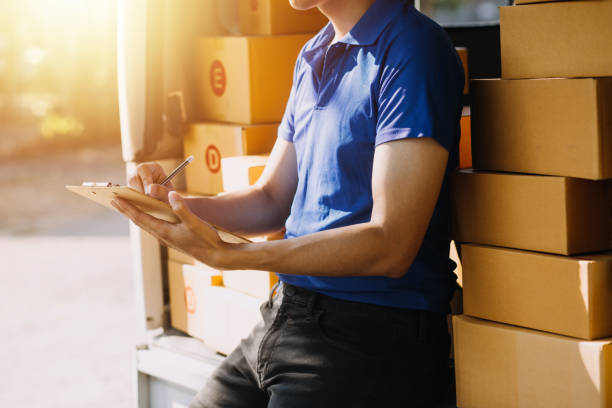 istock Blue Delivery Men Unloading Package From Truck With Face Mask 1649101638