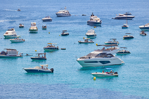 View of yachts and boats moored on the small bay with clear turquoise water
