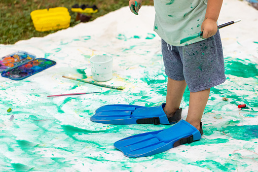 One happy child with a great idea decided to put on some flippers and paint