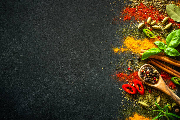istock Spices and herbs on black slate background. 1649195096
