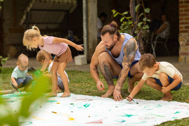 istock Father of three teaching kids how to paint 1649199893