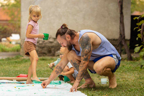 istock Father of three teaching kids how to paint 1649205310