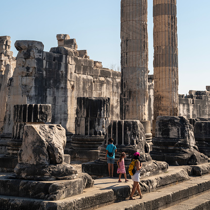 Full length photo of mother, 10 years old son and 5 years old daughter visiting ancient Greek city of Didyma in Aydin Province, Turkey. Shot during day time with a full frame mirrorless camera.