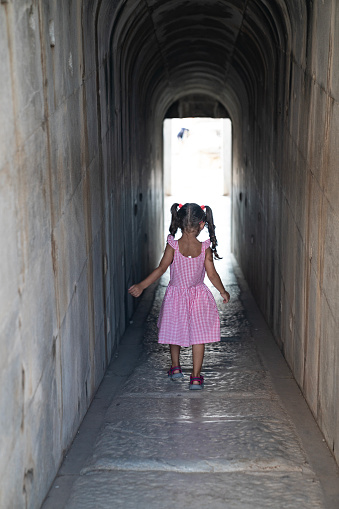 Rear photo of 5 years old girl walking in stone corridor of ancient Greek Temple of Apollo, Didyma, Aydin, Turkey. Shot with a full frame mirrorless camera.