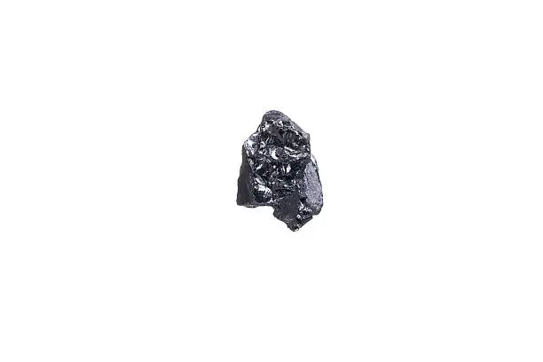 piece of a small Anthracite coal, isolated on white with a shallow depth of field