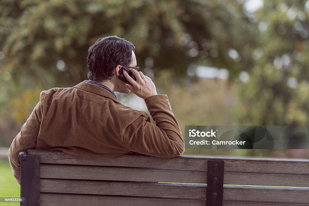 Hombre sentado en la mesa tomando una llamada - Foto de stock de Adulto libre de derechos