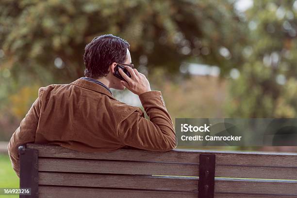 Hombre Sentado En La Mesa Tomando Una Llamada Foto de stock y más banco de imágenes de Adulto - Adulto, Adulto joven, Aire libre