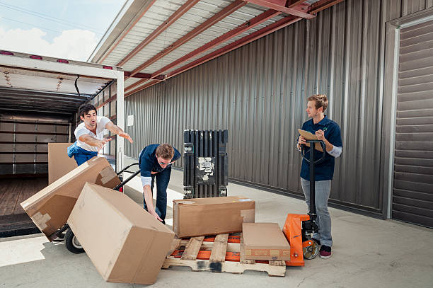 Careless Dock Workers Dropping Delivery Boxes While Loading Truck stock photo