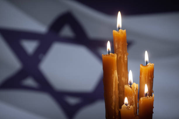 istock Six burning candles on Israel flag background. 1649233953