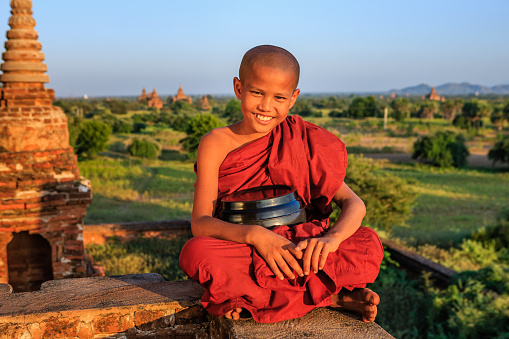 Young Buddhist monk admiring view of ancient temples in Bagan, Myanmar (Burma)