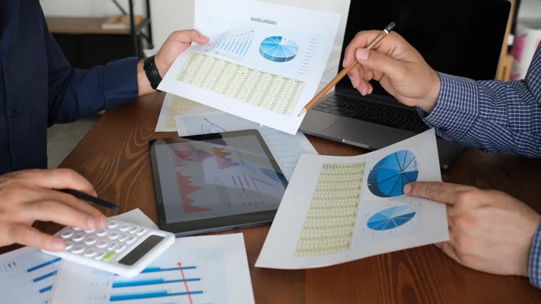 two businessmen discussing graphical data on tablet screen