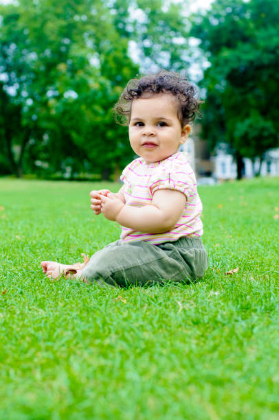 istock Baby Girl Sitting On Grass 164928576