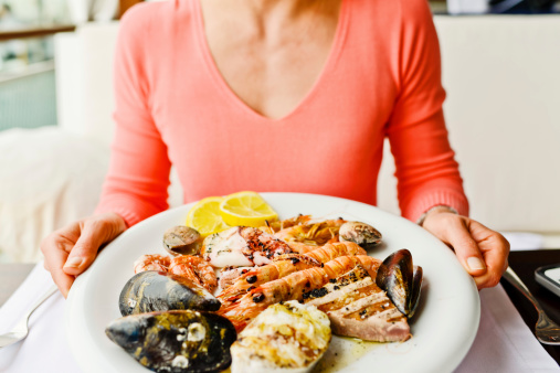 Woman eating Grilled Seafood in a restaurant