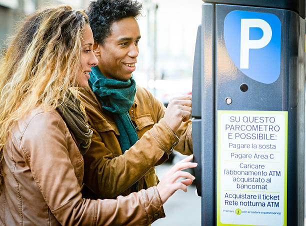 Lovely couple using parking ticket machine in the city