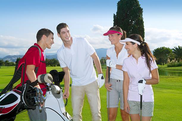 dois jovem homem e duas mulheres jovens em um campo de golfe - golf four people young adult playing imagens e fotografias de stock