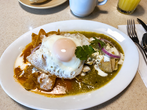 Mexican breakfast chilaquiles with red and green spicy sauce and egg