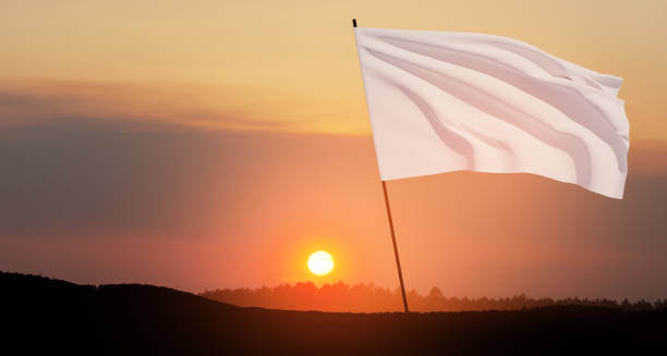istock White flag waving in the wind on flagpole against the sunset sky with clouds. 1649358161