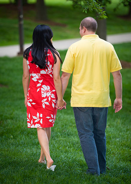 istock Young Mixed Ethnicity Couple Walks in Lush Urban Park Environment 164937137