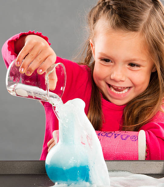 muito jovem cientista realização de uma experiência - girl01 imagens e fotografias de stock