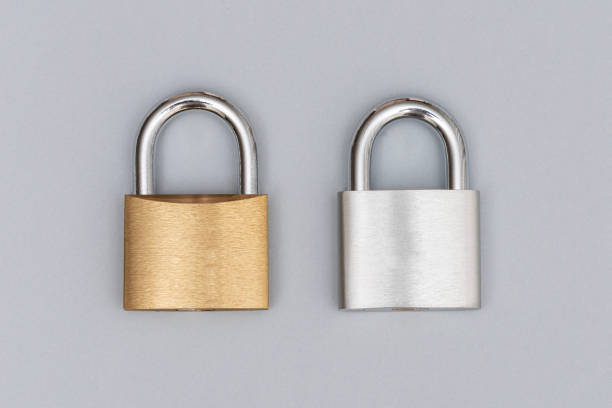 Locked silver and golden padlock on the gray background.