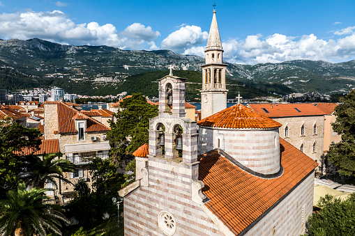 Beautiful old part of the city of Budva in Montenegro seen from a drone perspective with all its catholic and orthodox churches as well as incredible mountains in the background.