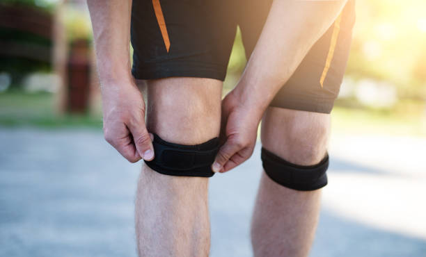 istock Knee support brace on male legs 1649404544