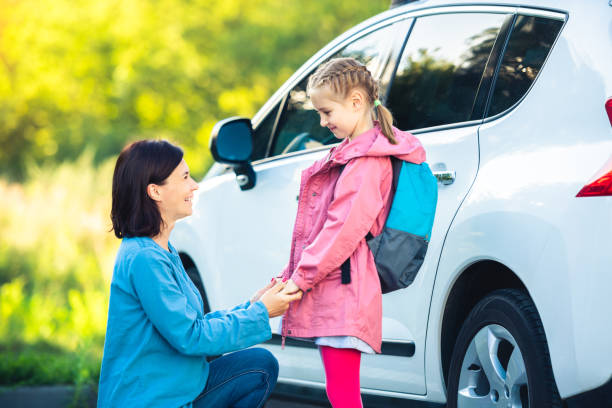 istock Smiling mother bringing daughter to school 1649441319