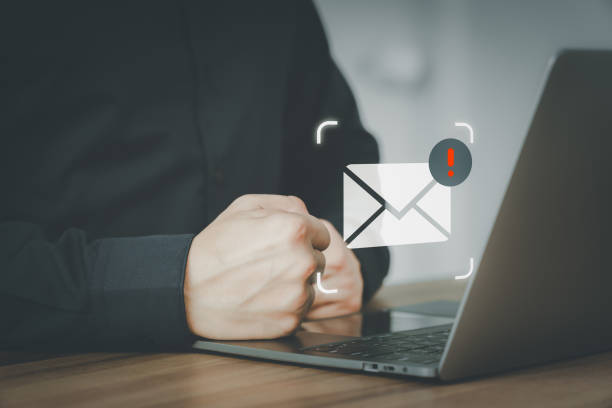 istock Male hand using a computer laptop with an email icon, Email alert with a caution warning sign for notification error. Security protection on the internet, junk mail, and compromised information. 1649457591