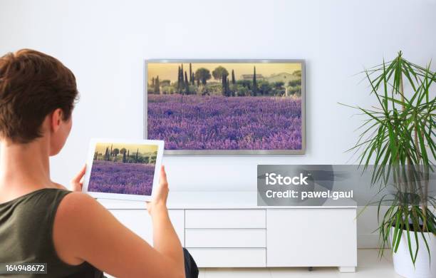 Mulher Usando Tablet Digital Para Ver Fotografias - Fotografias de stock e mais imagens de Televisor - Televisor, Aplicação móvel, Download