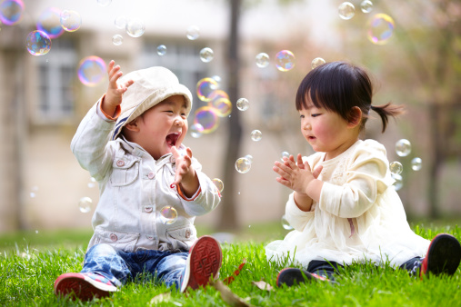 picture of happy asian kids playing bubble together outdoor in the park