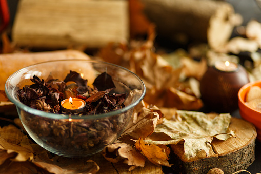 A bowl with scented potpourri and a small tea candle burning in the middle.