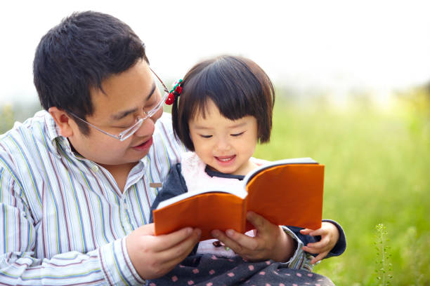 istock little girl reading book with father 164953499