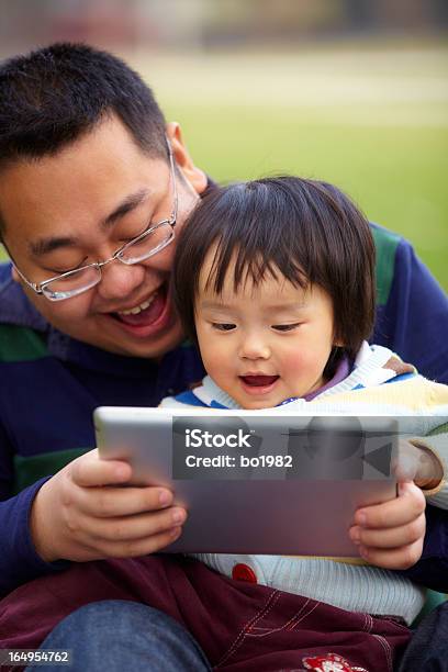 Joven Padre Con Su Hija Usando Tableta Al Aire Libre Foto de stock y más banco de imágenes de 12-23 meses