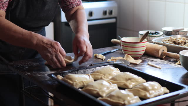 Culinary Tradition: Latin Elderly Woman Crafting Delicious Chilean Baked Empanadas de Pino in her Home Kitchen