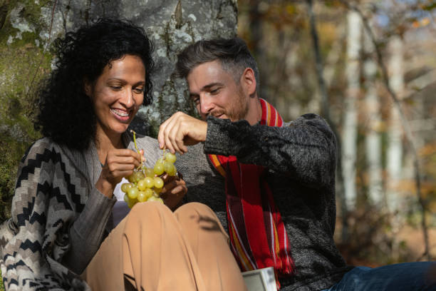 istock A couple eats grapes on a picnic in nature. 1649551464