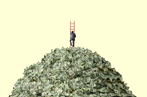 A man uses a ladder to climb out of a huge pile of debt.