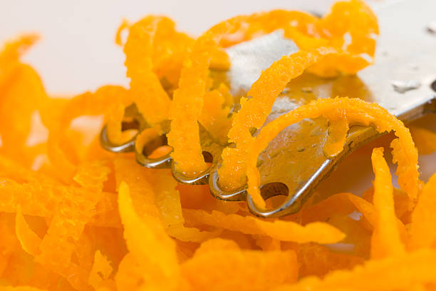 Citrus zester and thin strips of orange peel stock photo