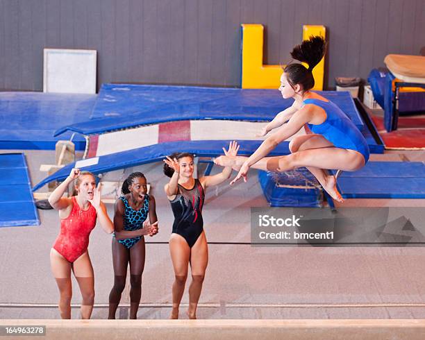 Молодой Женский Gymnasts Поддержи По Команде В Midair — стоковые фотографии и другие картинки Гимнастика