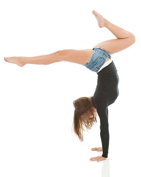 istock Experienced female gymnast doing stagged out hand stand (isolated) 164963556