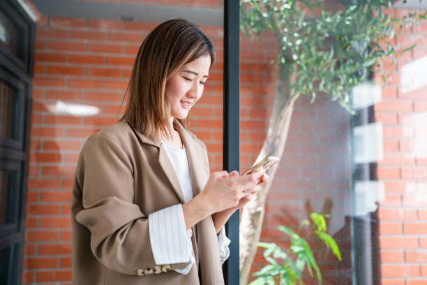 istock Happy relaxed young woman sitting on couch using cell phone, smiling lady laughing holding smartphone. 1649660668