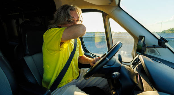 istock Distracted, drowsy driver yawning behind the wheel. Tired mature driver losing control on the road. Car interior 1649677615