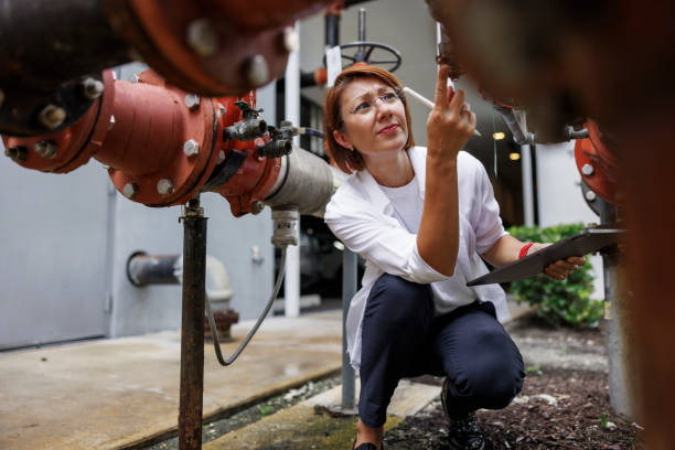 Pipe leakage and water supply checking in the yard. Redhead claim agent in squatting position identifying potential issues within water supply and distribution system.
