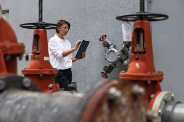 istock Fire hydrants checking and look for corrosion. Female claim agent with digital tab maintain metal quality and water distribution systems. Selective focus on woman 1649701693