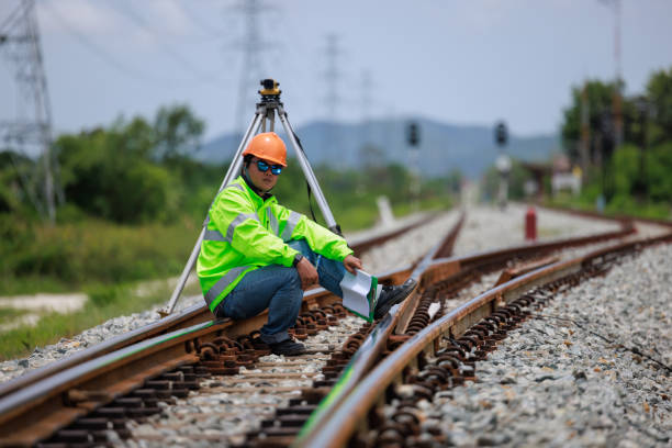 istock Engineer wearing hard hats and uniforms use theodolite equipment surveying construction worker on Railway site. 1649704367